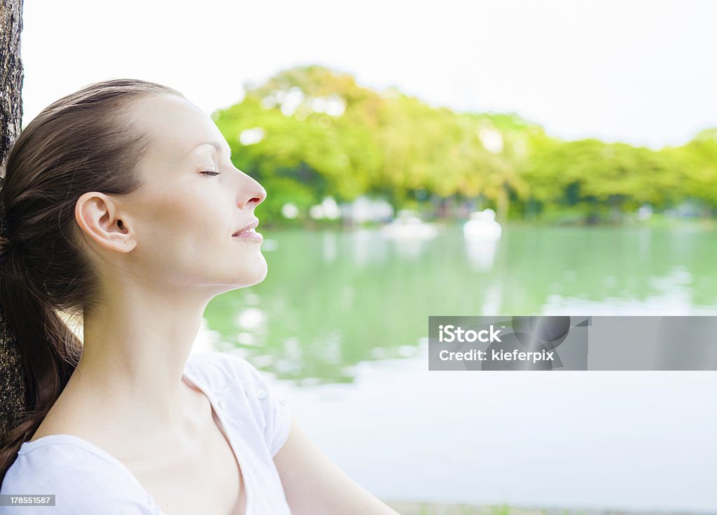 woman relaxing outdoors Enjoying the sun in the park. 20-29 Years Stock Photo