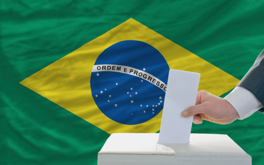 man putting ballot in a box during elections in brazil