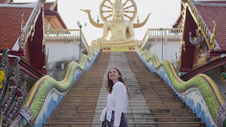 Cheerful woman exploring in Big Buddha Temple in Koh Samui