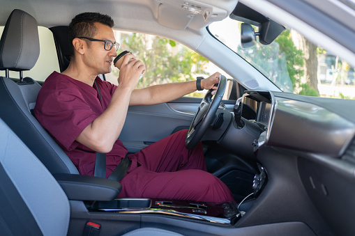Male Nurse In Medical Scrubs Driving Car