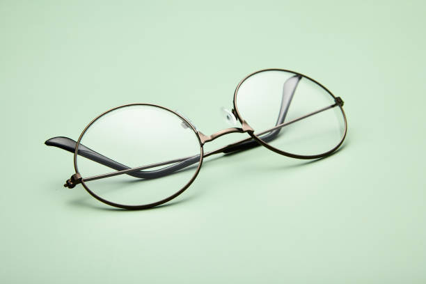 istock Open metal rimmed spectacles isolated on light-green. 1785536469
