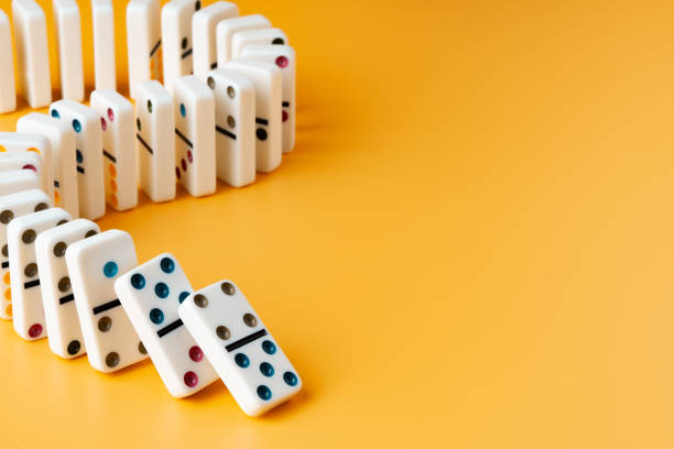 istock Row of domino tiles on yellow studio background 1785537004