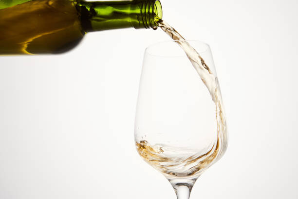 istock White wine pouring from green bottle, close up. 1785537535