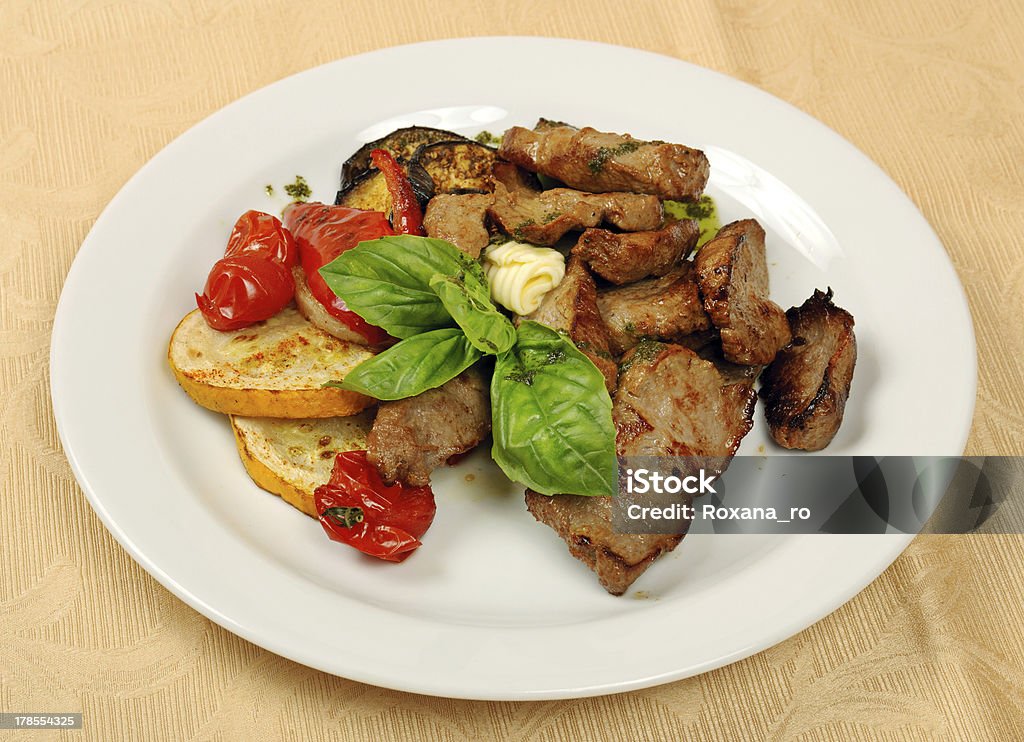 Roasted meat Roasted sliced meat with basil and tomato on dish in restaurant Asian Culture Stock Photo