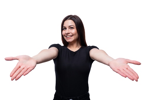 Young European woman dressed in a black T-shirt smiling on a white background with copy space.