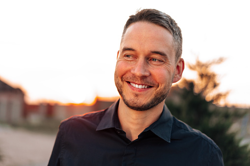 Portrait of handsome successful man standing outdoors close up