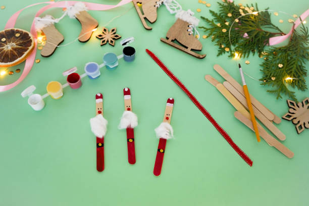 istock Step by step instruction how to make christmas toy from ice cream sticks. Step 5 we make a loop from a red ribbon and glue it to a toy. Children's New year handmade craft 1785552359