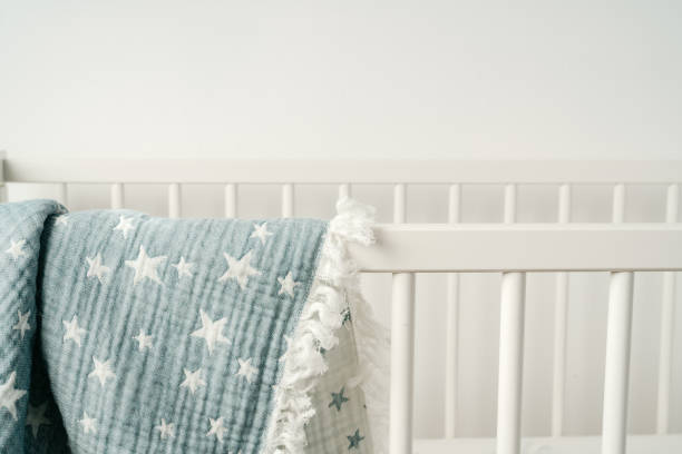 istock Soft blue muslin blanket hanging on a baby's bed 1785555580