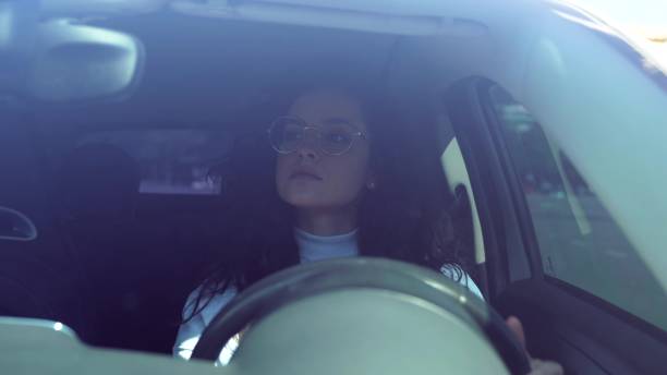 istock Beautiful adult driving a vehicle looking at road. Female driver beginner practicing learning to drive a car after getting licence. Close up. Caucasian woman with curly hair in car 1785560048