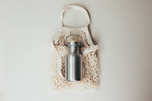 istock Devices for drinks. Zero waste concept. A tin bottle for water with beige mesh bag on beige background 1785565333