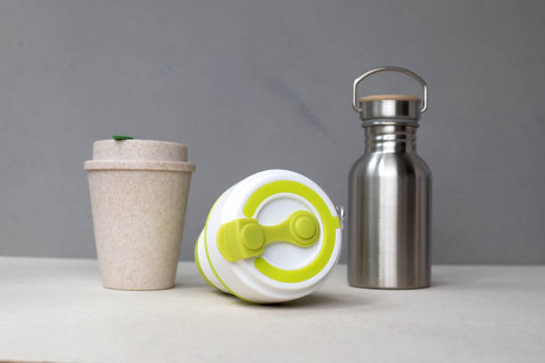istock Devices for drinks. Zero waste concept. A tin bottle for water and two reusable mugs on beige background 1785565340