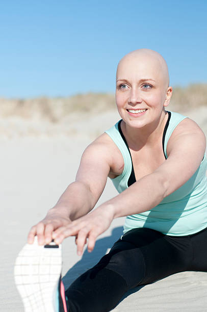 jovem mulher com bald head prática de desporto após resistir a quimioterapia - secondary action imagens e fotografias de stock
