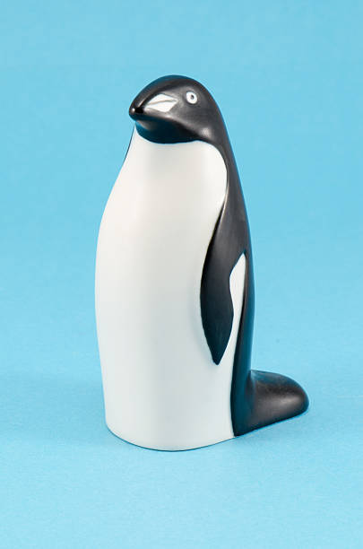 toy penguin figur zu hause auf blauem hintergrund-dekor - ceramic figure stock-fotos und bilder