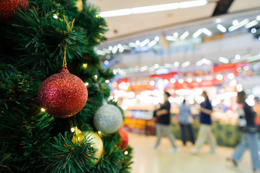 festive Christmas eve decorated in shopping mall with balls and Blurred people are walking in the shopping mall.