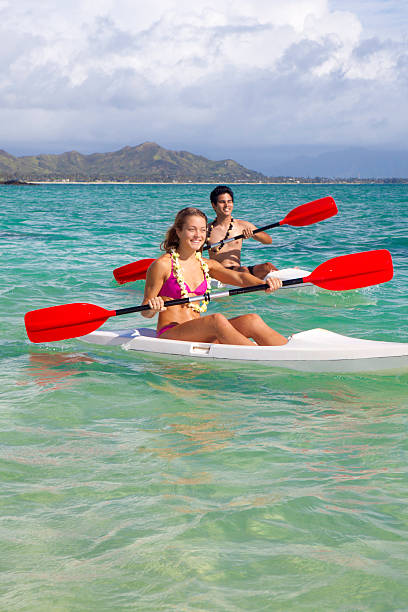 mixed couple paddling surfskis in hawaii