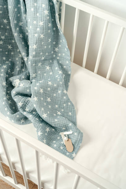 istock Soft blue muslin blanket hanging on a baby's bed 1785596957