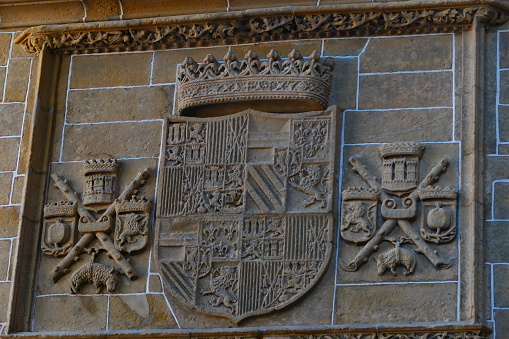Amsterdam, Netherlands: civic coat of arms of Amsterdam- red shield and a black pale with three silver Saint Andrew's Crosses - shield of Amsterdam on a brick wall.
