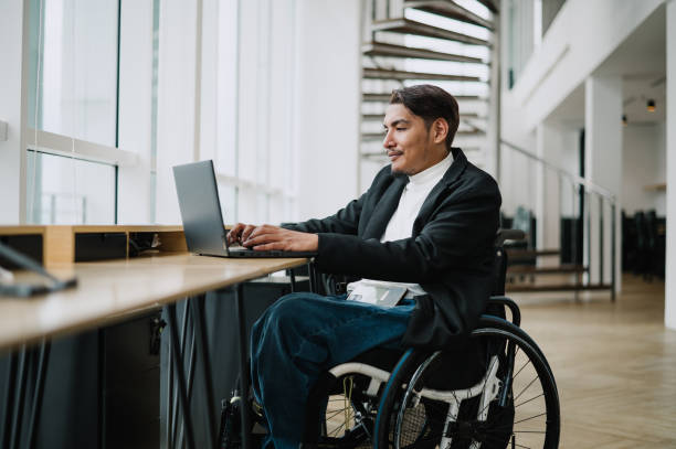 istock Asian Malay wheelchair businessman working alone in office. 1785598094