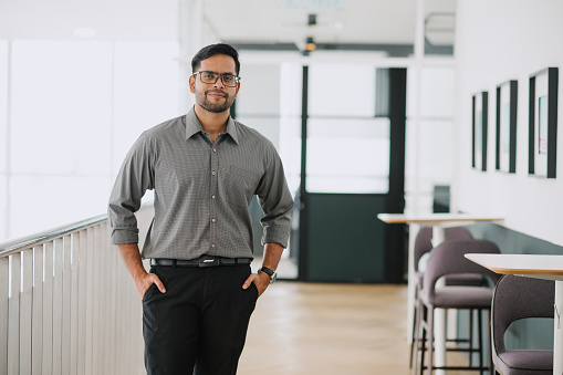Portrait of Asian Indian businessman standing at office.