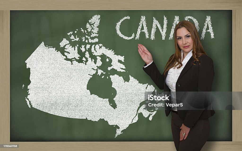 Insegnante mostrando la mappa di canada su lavagna - Foto stock royalty-free di Adulto