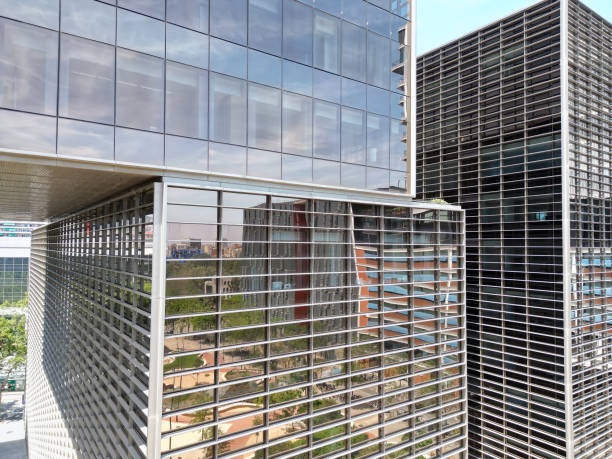istock Bottom view of office building window close up, reflection and perspective. Modern architecture with sun ray. Glass facade on a bright sunny day with sunbeams on the blue sky. 1785602105