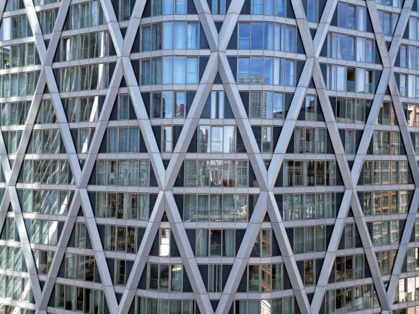 istock Bottom view of office building window close up, reflection and perspective. Modern architecture with sun ray. Glass facade on a bright sunny day with sunbeams on the blue sky. 1785603739