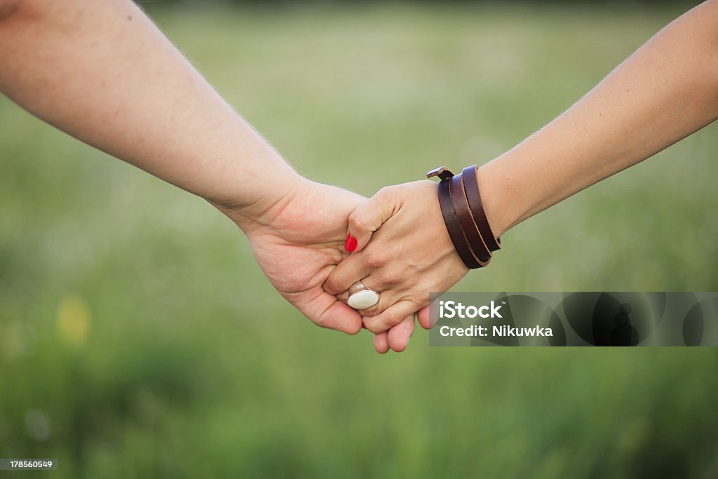 Couple Holding Hands Couple Holding Hands on a field Adult Stock Photo