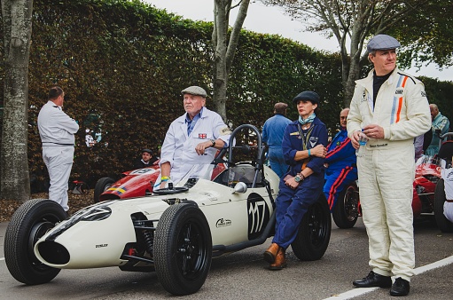 Goodwood, United Kingdom – September 17, 2021: A group of people standing near sports cars during the Goodwood Revival festival