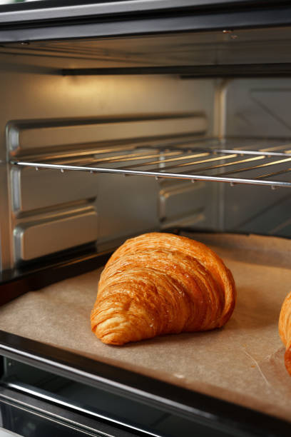 istock Modern mini electric oven with freshly baked croissants in kitchen 1785616337