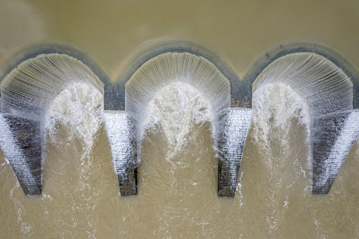 A close-up of a dam overflowing a reservoir with floods