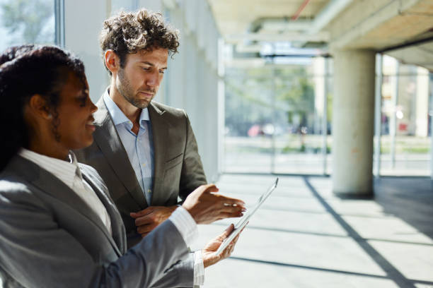 istock Diverse entrepreneurs working on digital tablet in a hallway. 1785623997