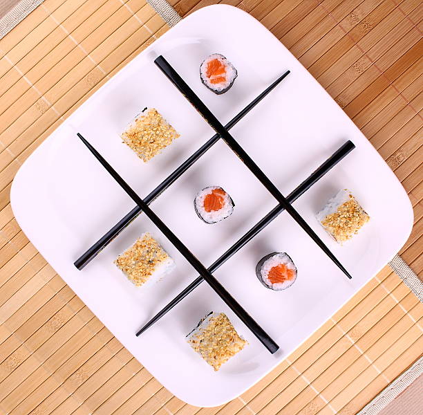 Tic tac toe play and chopsticks with sushi, close up