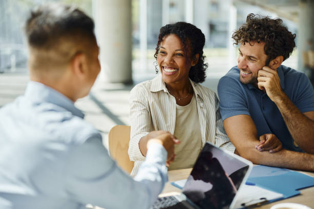 Successful deal with insurance agent! Happy diverse couple came to a successful agreement with their agent on a meeting in the office. insurance stock pictures, royalty-free photos & images