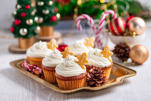 istock Cupcakes with gingerbread cookies and christmas lights on a white wooden table 1785632349
