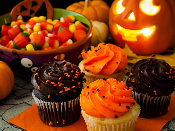 Halloween Cupcakes Halloween cupcakes with orange and black icing on orange napkin. halloween cupcake stock pictures, royalty-free photos & images