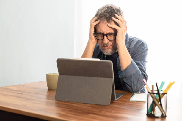 istock frustrated remote worker - Stressed Man at Home Office 1785651054