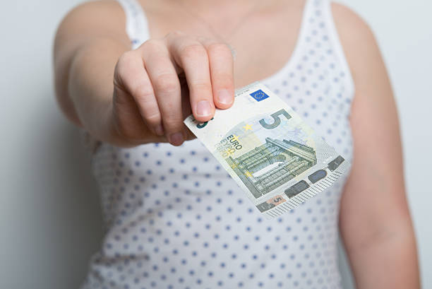 ragazza sta pagando con una nuova banconota da cinque euro - european union euro note european union currency paper currency five euro banknote foto e immagini stock