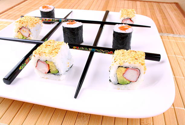 Play tic tac toe with sushi and black chopsticks