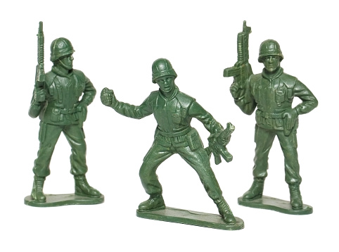 studio shot of toy soldiers on white background. All soldiers are carrying guns. One has a grenade.