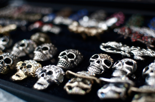 Team of metalic skull rings on display.
