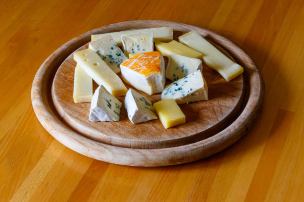 Cheese platter with different kinds of cheese on wooden table stock photo