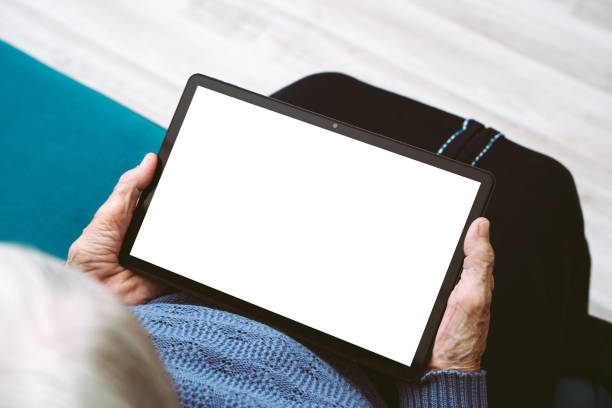 istock Wrinkled hands of an elderly woman holding mockup tablet computer with empty white blank screen for your text or design 1785676668