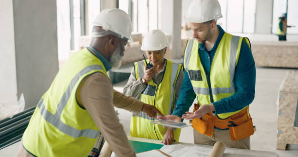 istock Engineering team, tablet and radio for project management, construction site planning and building renovation. Group architecture, digital technology and communication, blueprint or floor plan review 1785677295