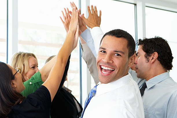 istock Businessman smiling while high -fiving team members 178568308