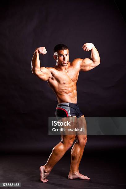 Joven Posando Bodybuilder Foto de stock y más banco de imágenes de Abdomen - Abdomen, Abdomen humano, Adulto