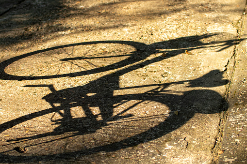 I took this photo one evening. When the sunlight starts to go down And it shines on the bicycle, creating a shadow on the road. I think it should represent a vehicle that protects the world's environment.