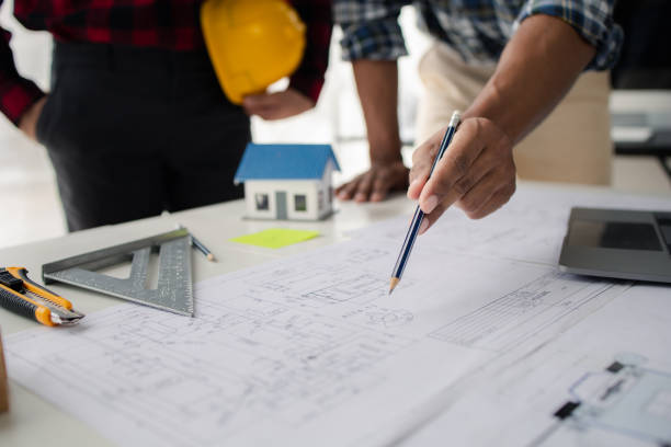 istock The home design architects are reviewing the house plan draft, the project commissioned by the client, and the custom design before delivery. Interior design and decoration ideas. 1785697483