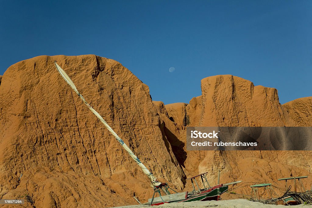 Red cliffs and clear blue sky in Canoa Quebrada, Brazil Red cliffs, natural relief from the coast of northeastern Brazil. Raft fisherman, boat typical of the coast of Ceará. Beach Stock Photo