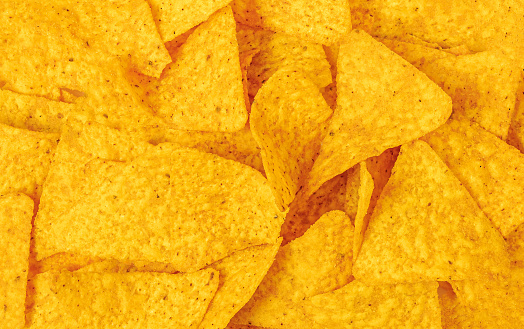 Nachos or tortilla chips texture background. Traditional Mexican food Top view. Pattern