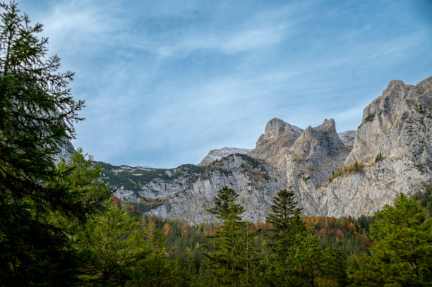 istock High rocky snowy mountain peaks in Alps with autumn forest. 1785723711